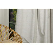 Cortină decorativă din material textil lângă un scaun de ratan lângă o fereastră