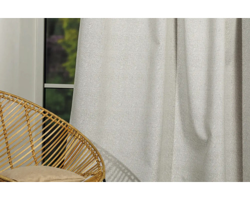 Cortină decorativă din material textil lângă un scaun de ratan lângă o fereastră