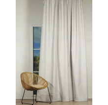 Cortină decorativă în fața unei ferestre cu un scaun de răchită în cameră