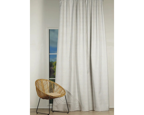 Cortină decorativă în fața unei ferestre cu un scaun de răchită în cameră