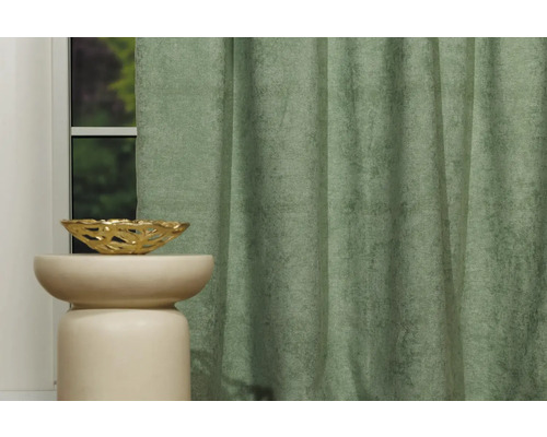 Cortină decorativă verde lângă un pervaz cu un bol auriu.