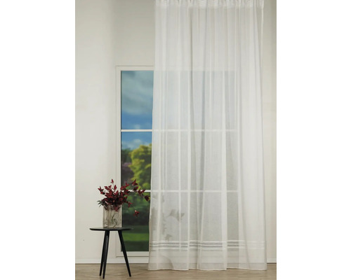 Perdea transparentă în fața unei ferestre cu o mică decorațiune de masă