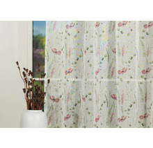 Șaluri decorative cu model floral în fața unei ferestre.
