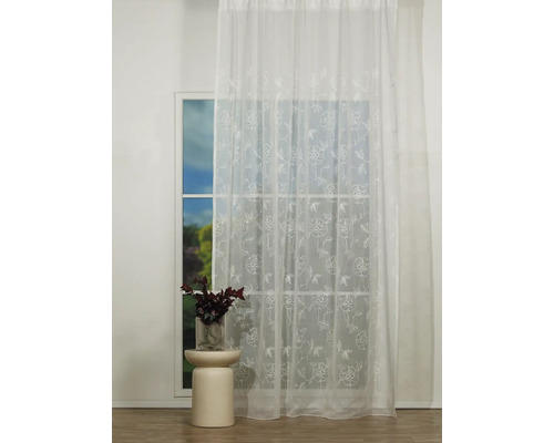 Perdea cu model floral în fața unei ferestre