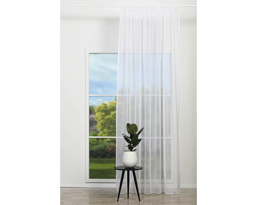 Cameră luminoasă cu fereastră, perdea și plantă pe o măsuță laterală