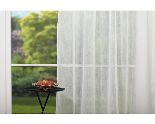 Fereastră cu perdea transparentă și masă mică