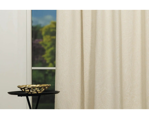 Cortină decorativă pentru fereastră lângă o măsuță laterală cu un bol.