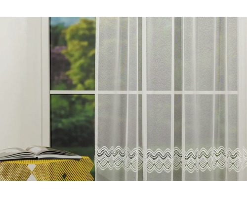 Cortină transparentă cu model de dantelă în fața unei ferestre