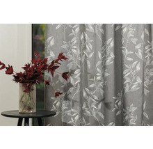 Cortină decorativă cu model floral lângă o măsuță laterală cu o vază de flori