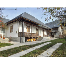 O casă rurală cu verandă și țiglă gri.