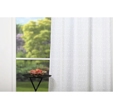 Perdea decorativă, albă, cu model punctat în fața unei ferestre