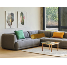 Canapea de colț gri cu perne și măsuță de cafea în camera de zi.