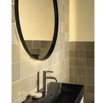 Baie modernă cu oglindă ovală, lavoar dreptunghiular şi perete cu faianţă