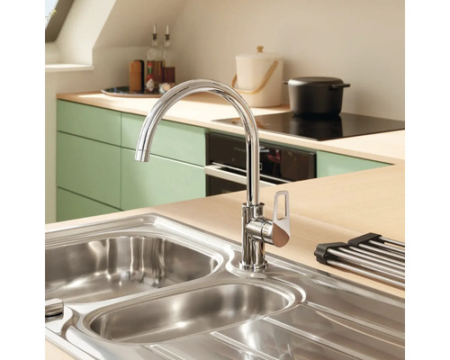 Chiuvetă de bucătărie cu robinet într-o bucătărie luminoasă.