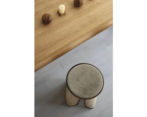 Vedere de sus a unui taburet rotund cu tapițerie din blană și a unei mese din lemn cu decorațiuni