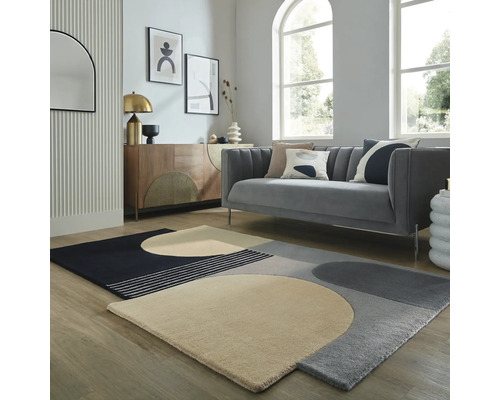 Living cu canapea gri și covor geometric pe podea de lemn