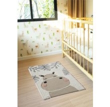 Cameră de copii cu covor și motiv animal lângă un pătuț