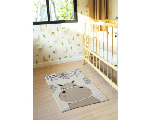 Cameră de copii cu covor și motiv animal lângă un pătuț
