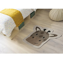 Scenă de cameră cu pat, pernă de șezut și covor în formă de cap de girafă.