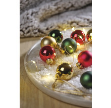 Globuri decorative de Crăciun pe o farfurie cu zăpadă artificială și șir de lumini