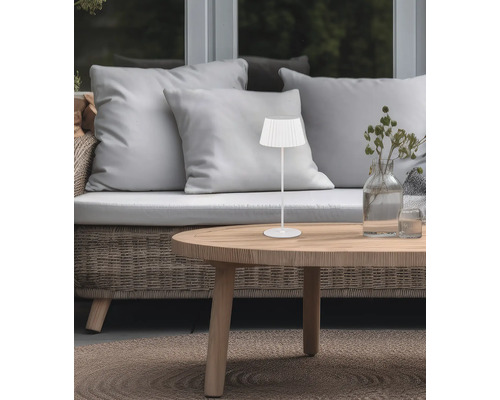 Lampă de masă decorativă pe o masă de lemn lângă o canapea