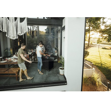 Scenă cu oameni care fac grătar pe o terasă și se bucură de un grătar în aer liber.