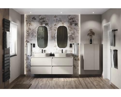 Baie luminoasă cu chiuvetă dublă, dulap sub chiuvetă, oglinzi și tapet floral.