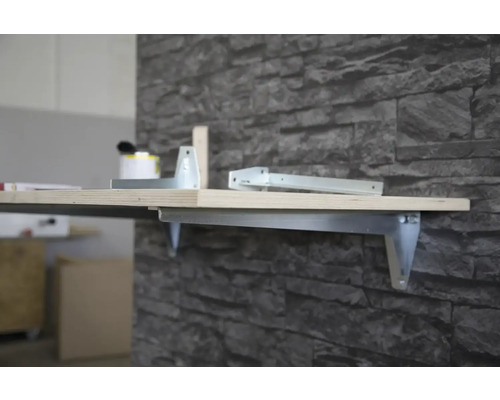 Raft de perete cu suport metalic și placă de lemn pe un perete de piatră