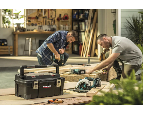 Scenă de atelier cu cutie de scule, ferăstrău de mână și doi meșteri la lucru