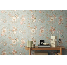 Prim-plan al unui perete cu tapet floral și o măsuță laterală cu obiecte decorative.