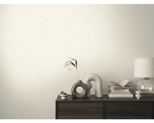 Cameră decorativă cu o comodă, cu cărți, o lampă și vaze deasupra.