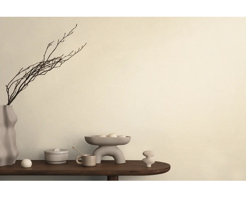 Aranjament decorativ cu vază, ramuri, bol și obiecte ceramice pe o masă.