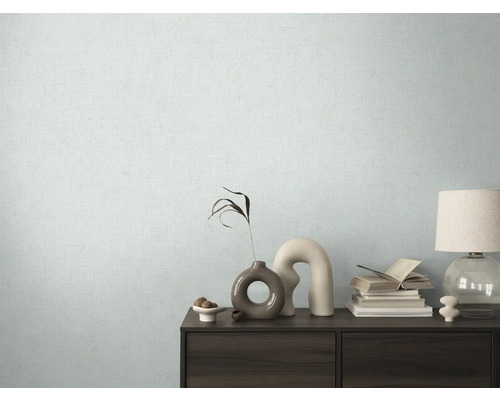 Cameră de zi cu tapet modelat și comodă cu elemente decorative.
