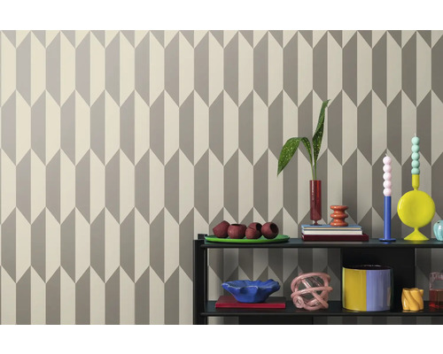 Tapet cu model geometric de săgeți în spatele unui raft cu decorațiuni.