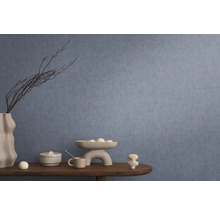 Interior decorativ cu tapet albastru, masă cu decorațiuni precum vază, bol și figurine ceramice