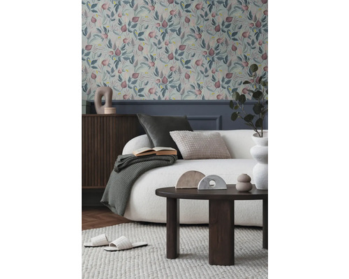 Cameră de zi cu tapet cu model floral, canapea, masă și decorațiuni pentru o ambianță primitoare.