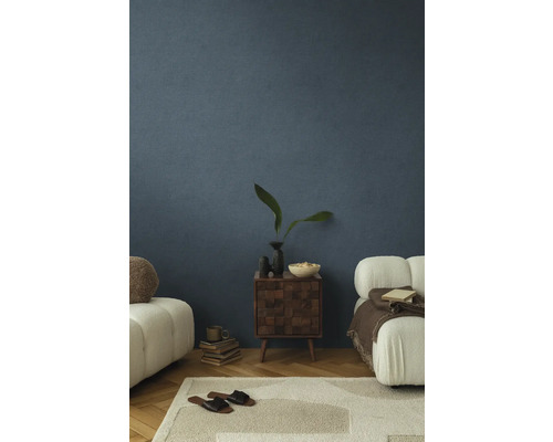 Cameră de zi cu pereți albaștri texturat, covor, mobilier și obiecte decorative