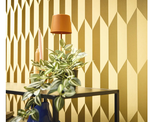Tapetă decorativă aurie cu model geometric de săgeți într-un interior.