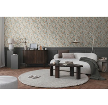 Cameră de zi cu tapet floral, canapea, covor și mobilier din lemn pentru o ambianță primitoare.