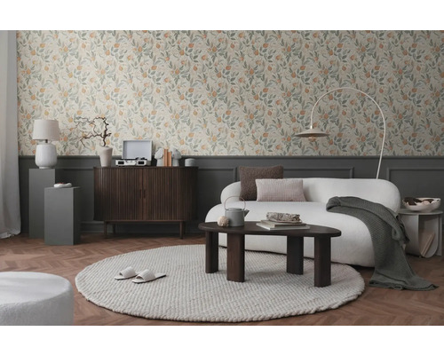 Cameră de zi cu tapet floral, canapea, covor și mobilier din lemn pentru o ambianță primitoare.