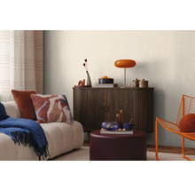 Scenă de living cu canapea, perne, pătură, dulap, lampă și decorațiuni pentru o atmosferă confortabilă