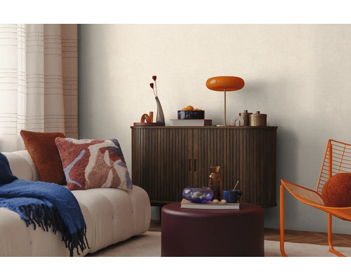 Scenă de living cu canapea, perne, pătură, dulap, lampă și decorațiuni pentru o atmosferă confortabilă