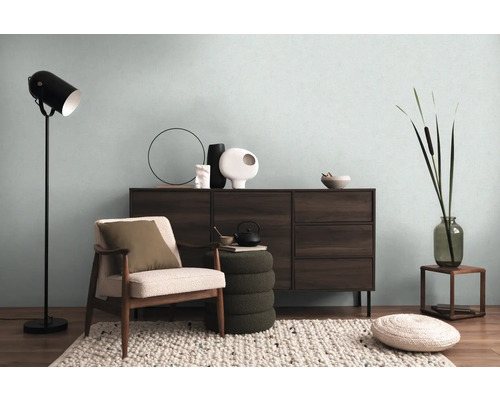 Cameră de zi cu comodă, fotoliu, lampadar și elemente decorative pentru o atmosferă confortabilă