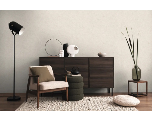 Interior cu fotoliu, lampă de podea, comodă și elemente decorative pentru o atmosferă primitoare.