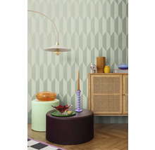 Cameră decorativă cu tapet geometric, lampă de podea, comodă și măsuțe laterale.