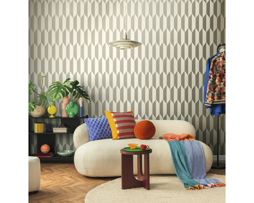 Living cu tapet geometric, canapea, măsuță laterală și elemente decorative pentru o ambianță stilată.