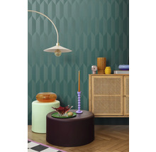 Interior cu perete decorativ, lampă, comodă și elemente decorative pentru o ambianță elegantă.
