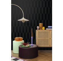 Mobilier într-o cameră cu tapet cu model geometric, lampadar și dulap din lemn