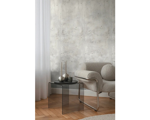 Interior cu tapet cu aspect de beton, fotoliu și măsuță laterală