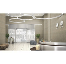 Zona de intrare a unui hotel cu ușă rotativă, recepție și corpuri de iluminat rotunde pe tavan